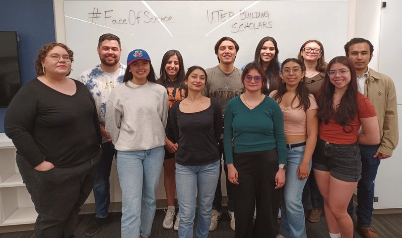 Group photo of 12 UTEP BUILD scholars standing in front of a whiteboard with "#FaceOf Science UTEP BUILD Scholars" written on it. 