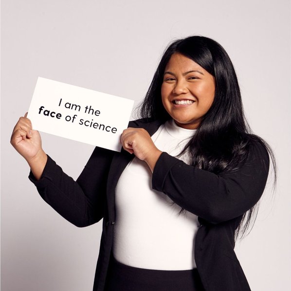Jamie Michelle L. Prudencio smiling a holding up a sign that says "I am the face of science"