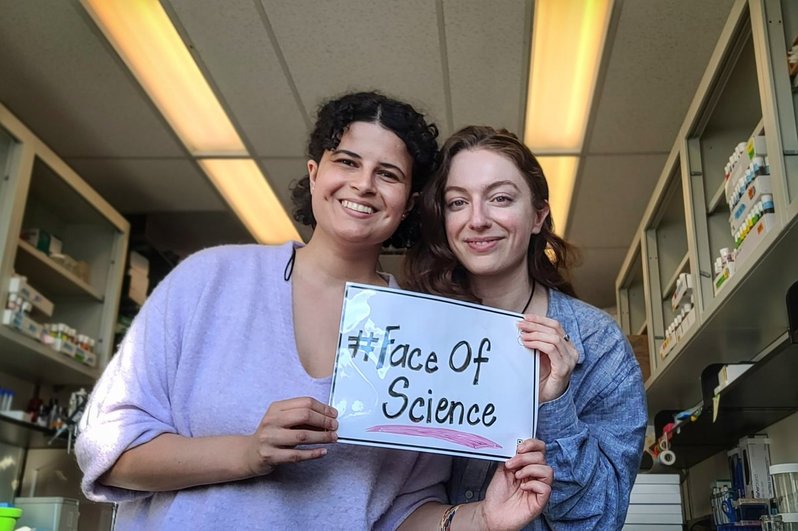Photo of Bri and Therande holding a sign that reads #FaceOfScience 