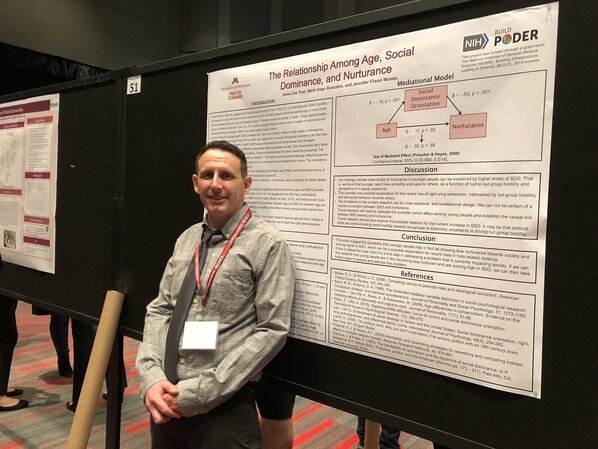Zak Peet stands in front of his research poster.