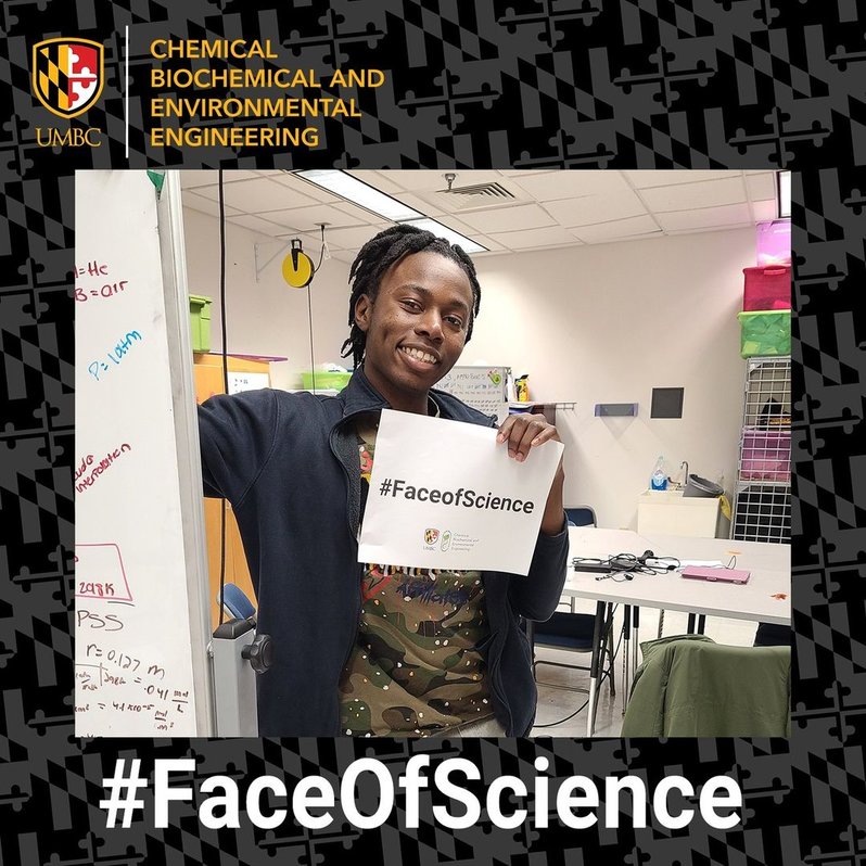 Chiad Onjeye, a chemical engineering undergraduate student and undergraduate researcher at UMBC holding a piece of paper with #FaceOfScience.