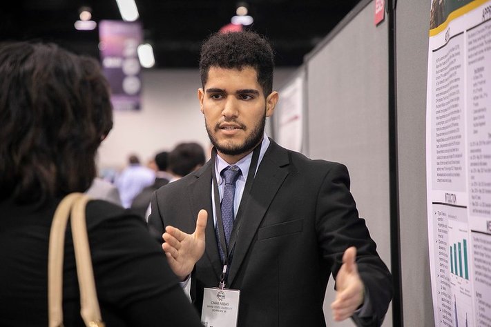A student researcher presenting their poster at ABRCMS in 2018.
