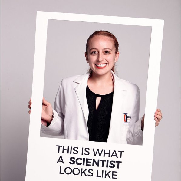 Aiyana Ponce smiling and holding a picture frame that says "This is what a scientists looks like"