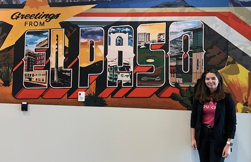A recent photo of Cecilia Hinojosa at UTEP by a large El Paso mural. She is wearing a “Mija yes you can” shirt.