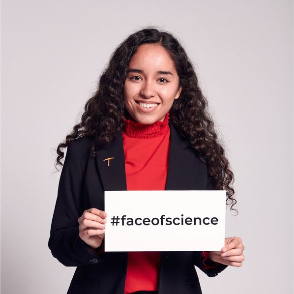 Cynthia Bautista smiling and holding a sign that says #faceofscience