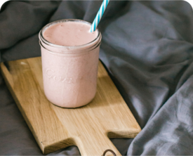 Image of a pink smoothie in a glass jar with straw.