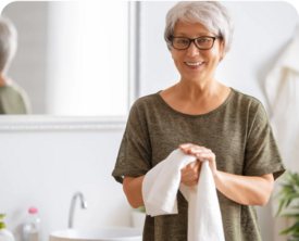 Image of older woman drying her hands on a handtowel.