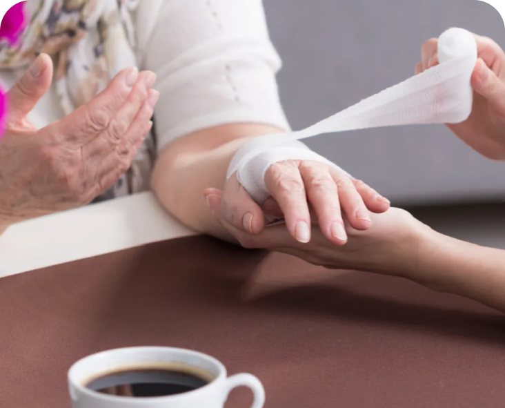 Image of a person bandaging an older woman's hand.