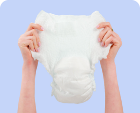 Image of two hands holding up an adult diaper.