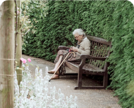 Image of woman sitting on a bench with a cane