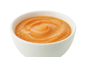 Orange pureed food in a white bowl