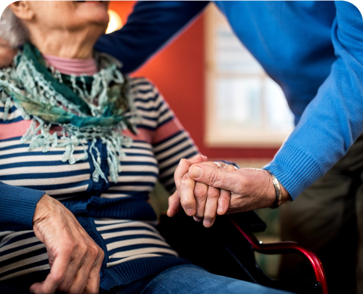 Image of someone assisting an older woman in a wheelchair.