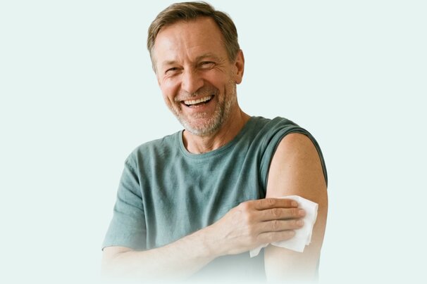 Happy senior man using a white wipe on his arm