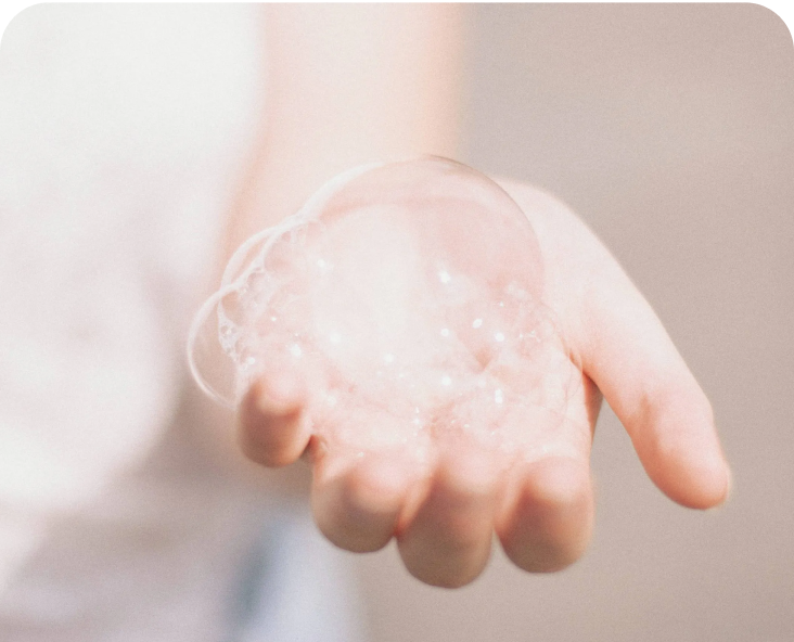 Image of an adult hand holding bubbles in their palm.