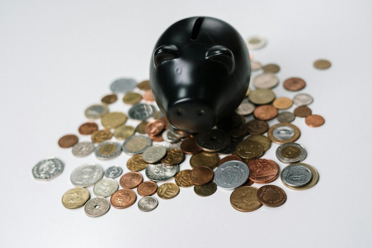 Guaranteed pre settlement funding hero image. This is a picture of a black piggy bank with coins.