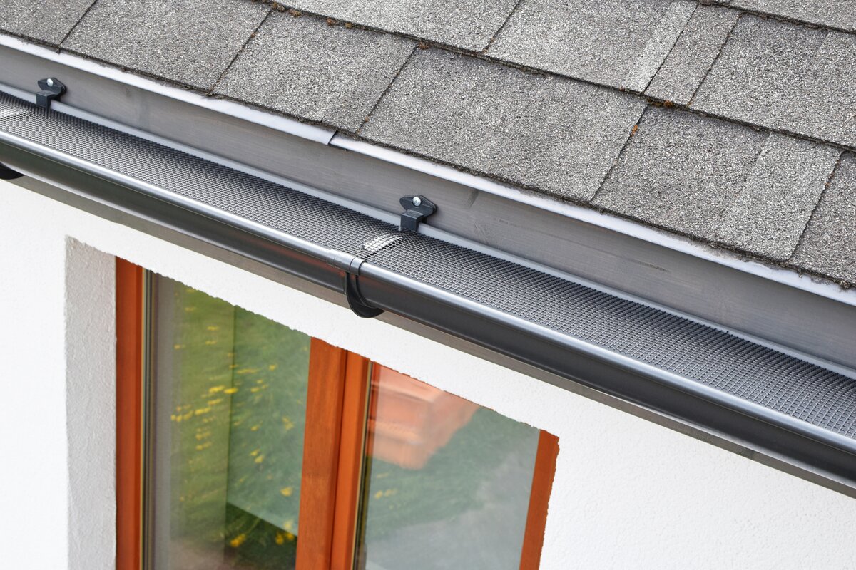 Image of newly installed gutter guards above window on home