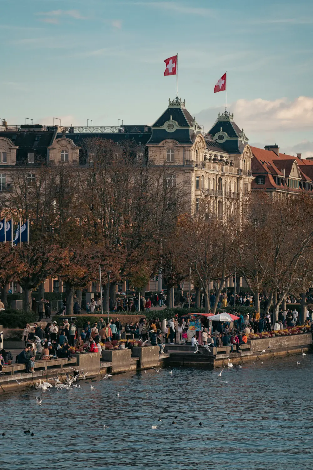 Historic riverside buildings and flags along the water in Lucerne, Switzerland