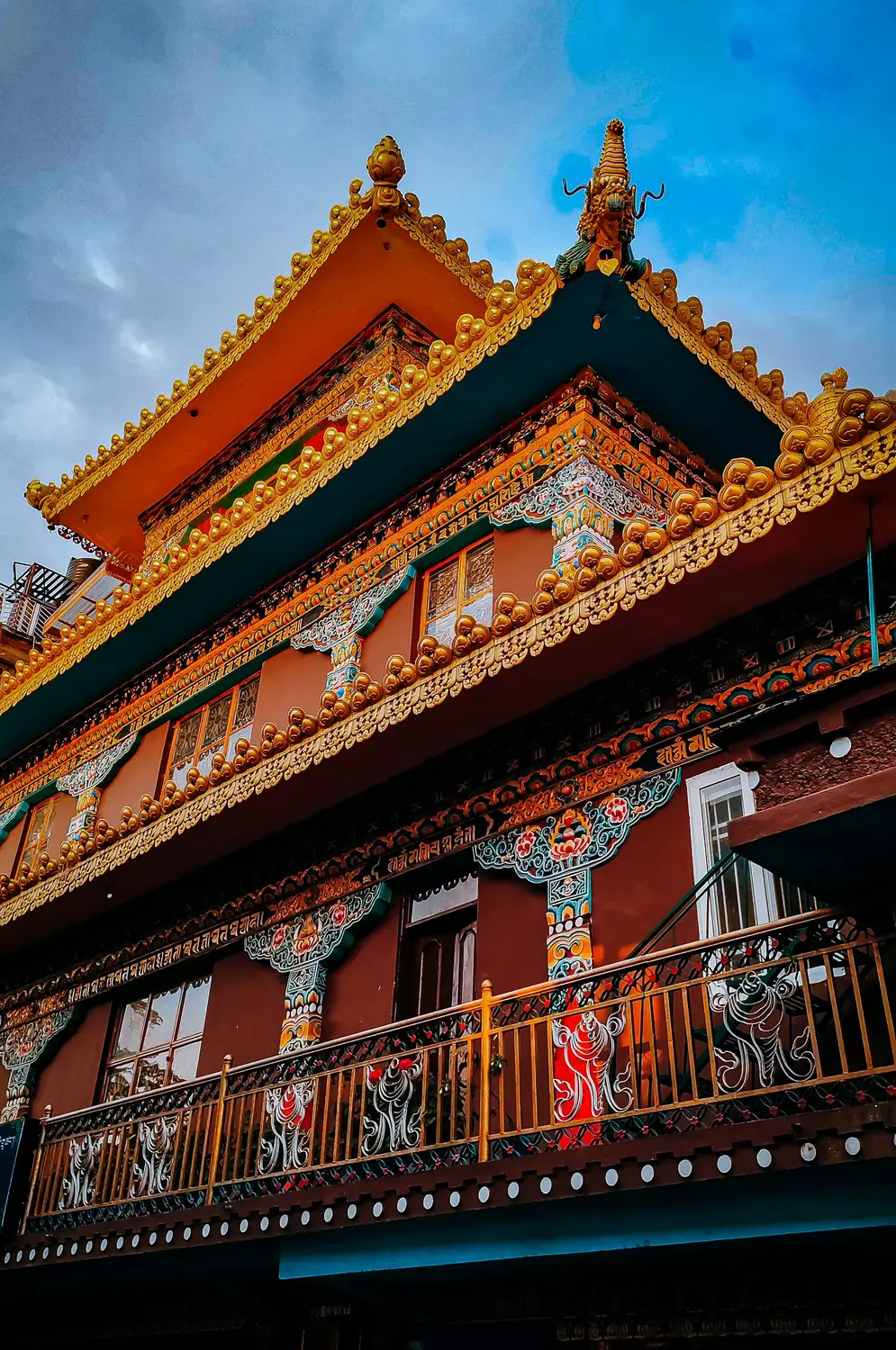 Colorful Tibetan Buddhist monastery facade with golden ornaments and traditional painted motifs, Sikkim, India