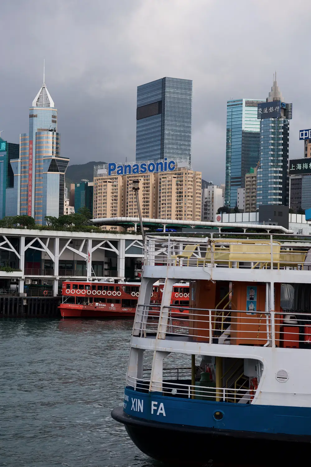 Star Ferry boat crossing Victoria Harbour with the illuminated Hong Kong Island skyline behind it in Hong Kong.