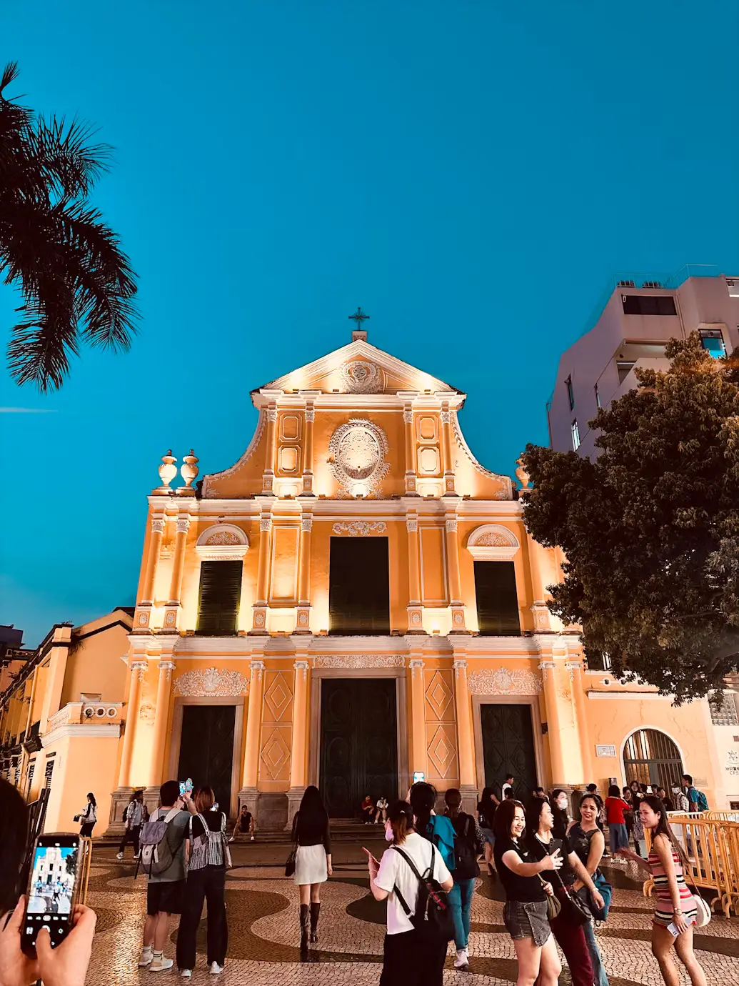 St. Dominic's Church cream-colored baroque facade with tourists in Senado Square, Macau