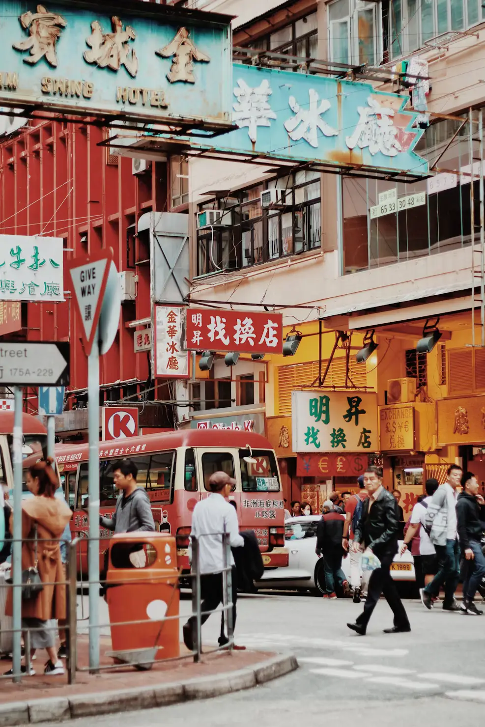 Bustling old street scene with traditional Chinese shop signs and pedestrians in Hong Kong.