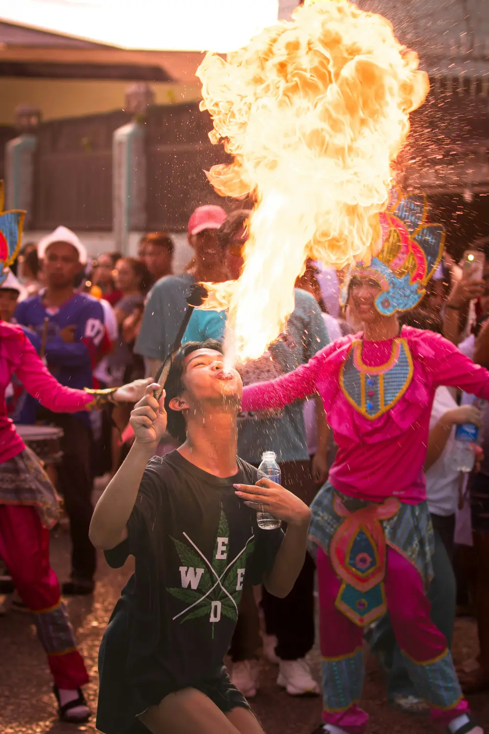 Fire-breathing street performer entertaining a crowd at a festival in the Philippines.