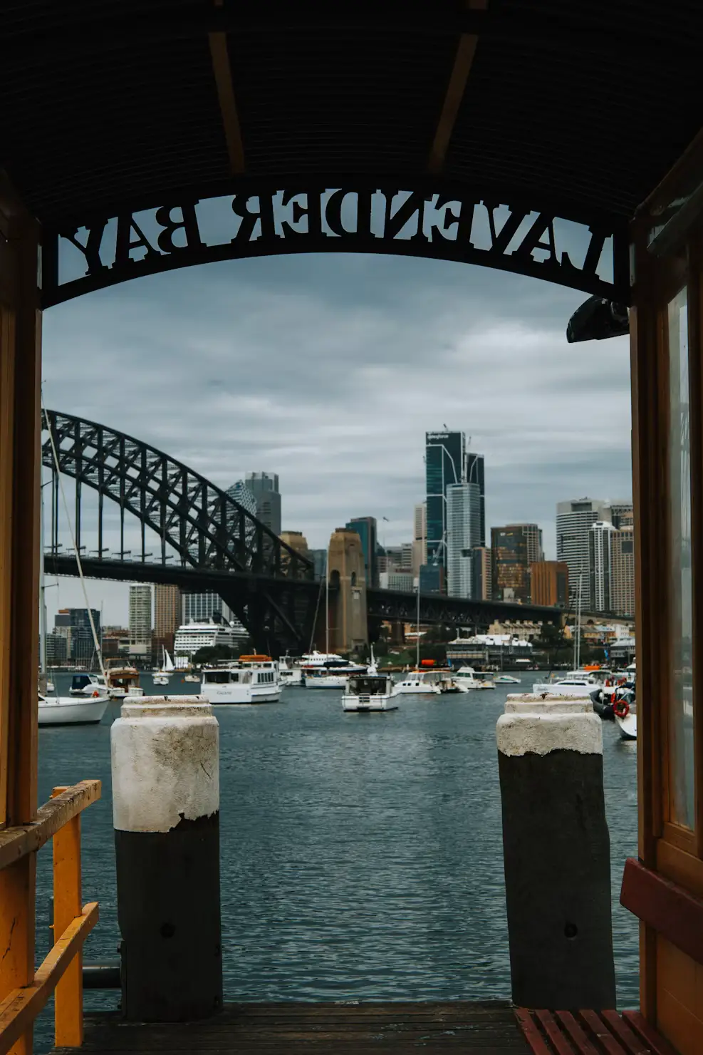 Sydney Harbour Bridge and city skyline framed through a wharf archway