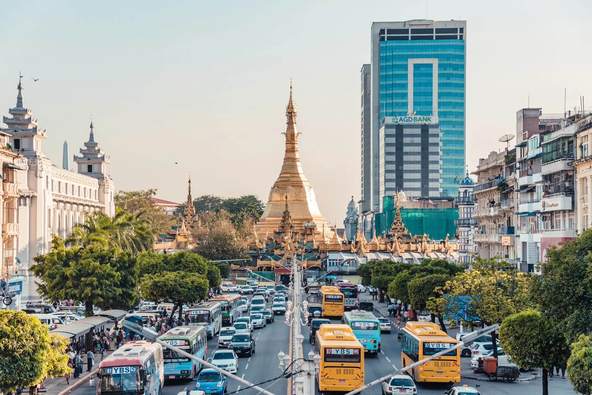 Busy downtown Yangon street with Sule Pagoda and modern city buildings in Myanmar