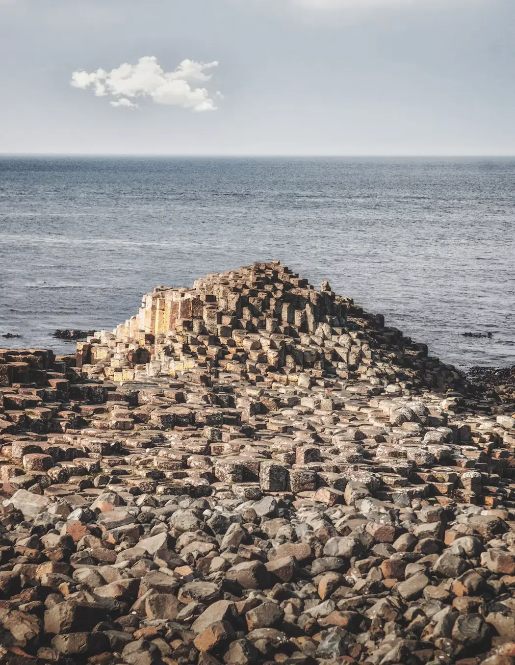 Hexagonal basalt rock formations stretching along the coastline into the sea, Giant's Causeway, Ireland.