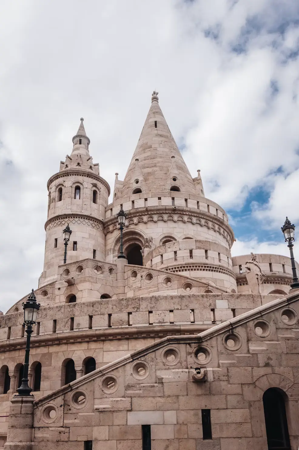 White stone towers and terraces rising beneath a cloudy sky.