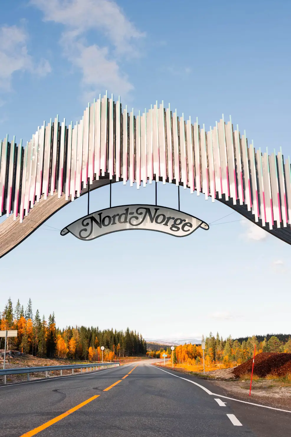 The decorative Nord-Norge arch spanning a highway, marking the gateway to northern Norway.