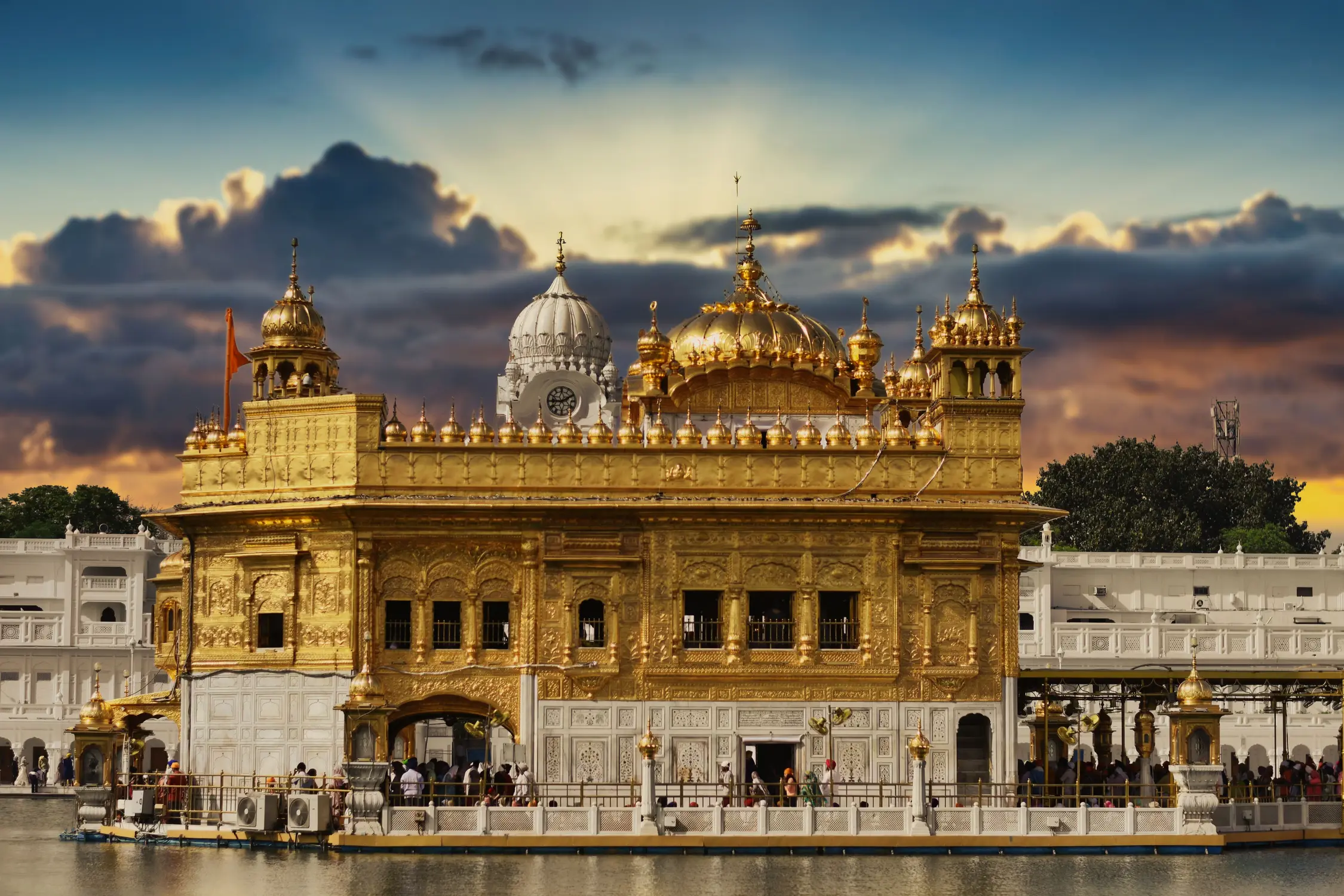 Golden Temple Harmandir Sahib gold-plated Sikh gurdwara surrounded by Amrit Sarovar lake at sunset, Amritsar, Punjab, India