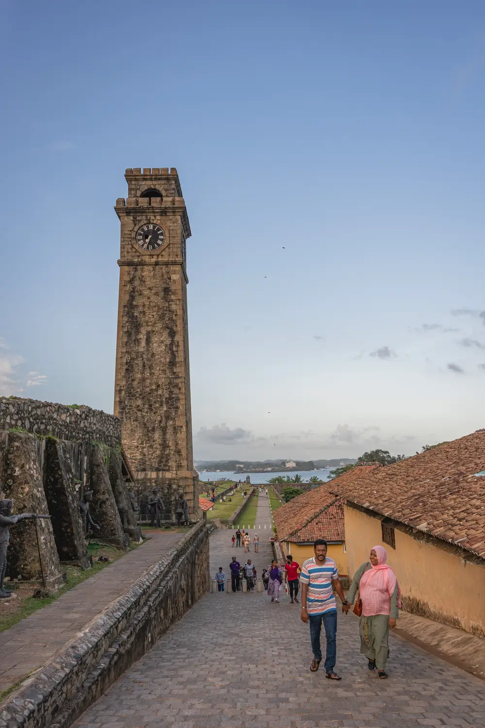 Historic stone clock tower rising above tiled rooftops within the Galle Fort walls in Sri Lanka.
