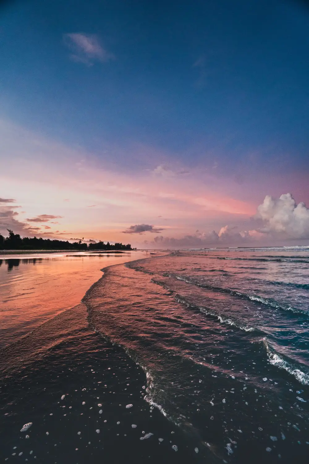 Golden hour sunset reflecting on Cox's Bazar beach waves with colourful twilight sky, Bangladesh