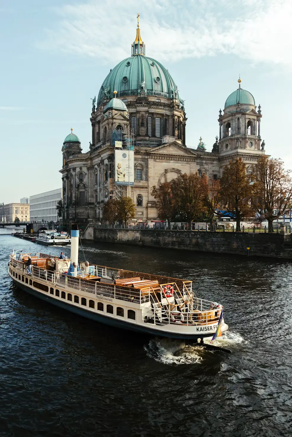 Passenger boat cruising past Berlin Cathedral on the Spree River