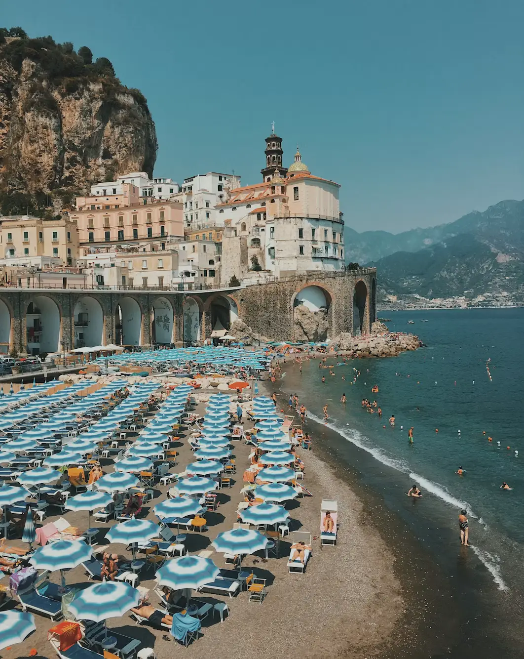 Aerial view of Atrani beach with striped umbrellas along the Amalfi Coast
