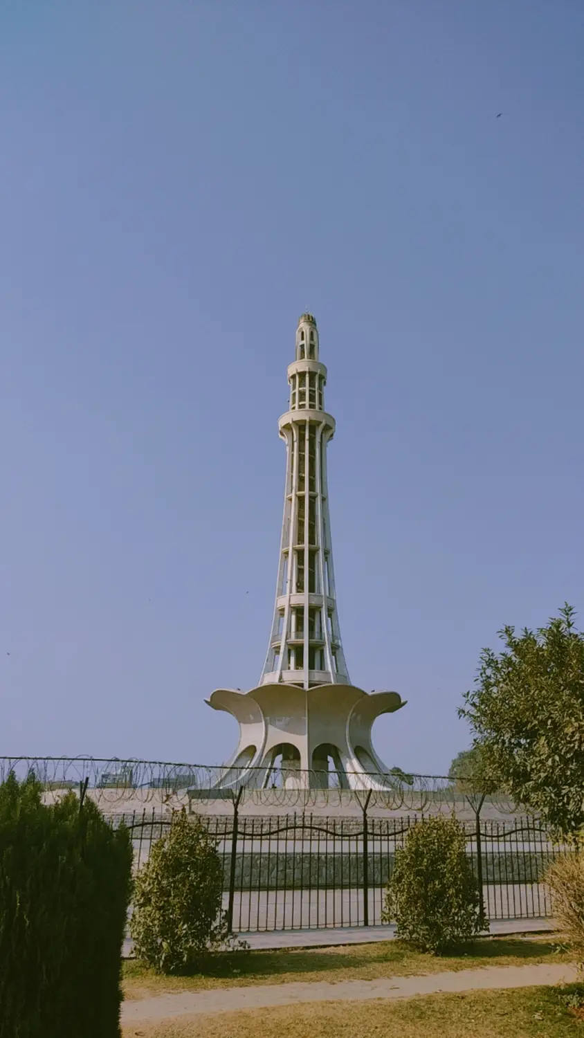 Minar-e-Pakistan independence monument tower at daytime with green hedges Lahore Pakistan