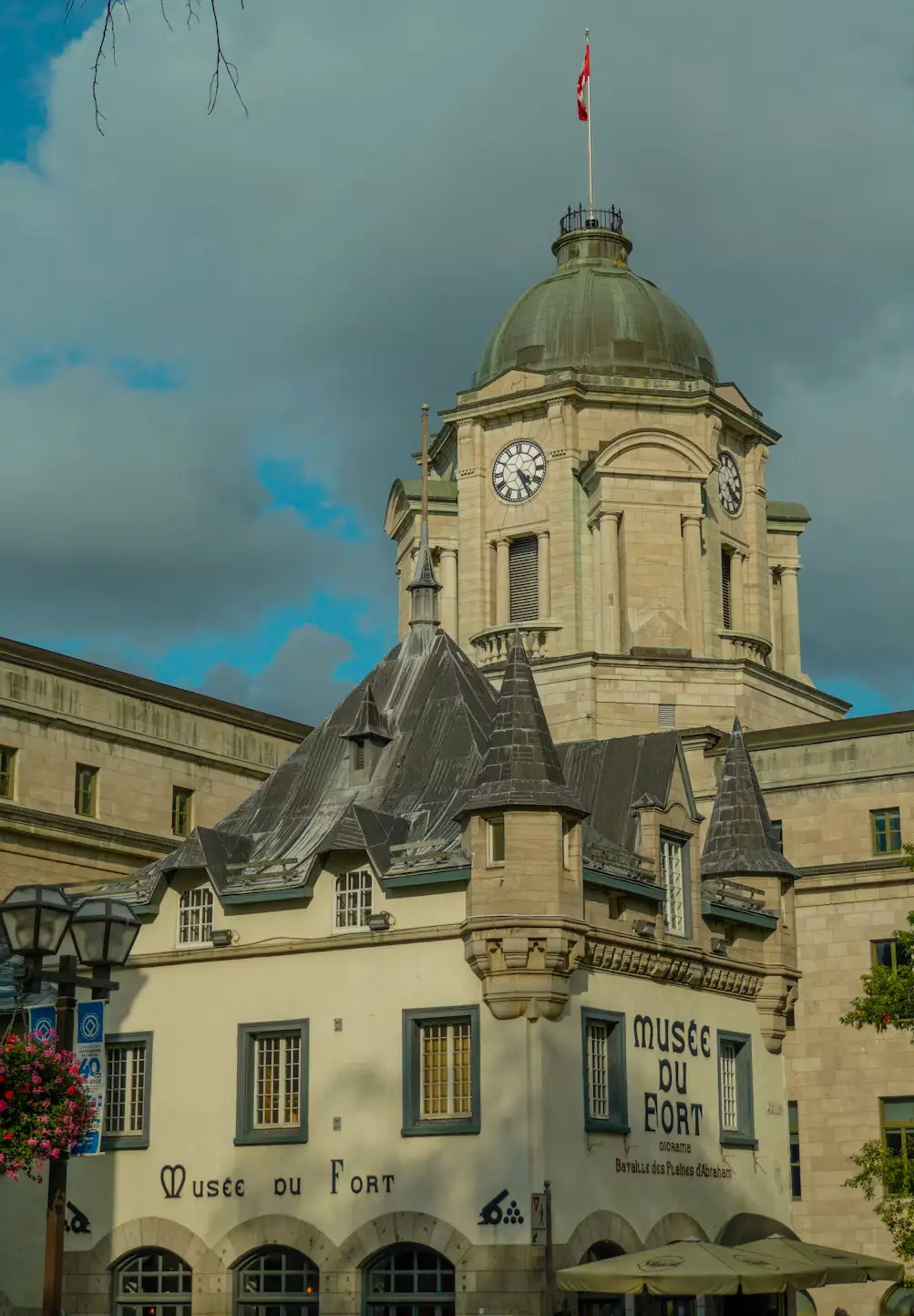 A historic stone building with a domed clock tower, housing a museum, under a partly cloudy sky.