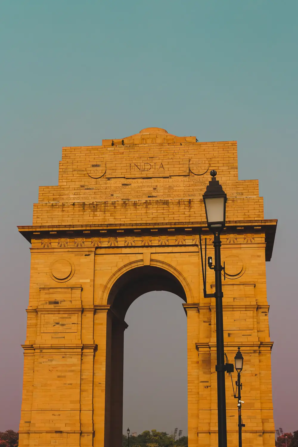 India Gate war memorial sandstone triumphal arch at dusk with vintage street lamp, New Delhi, India