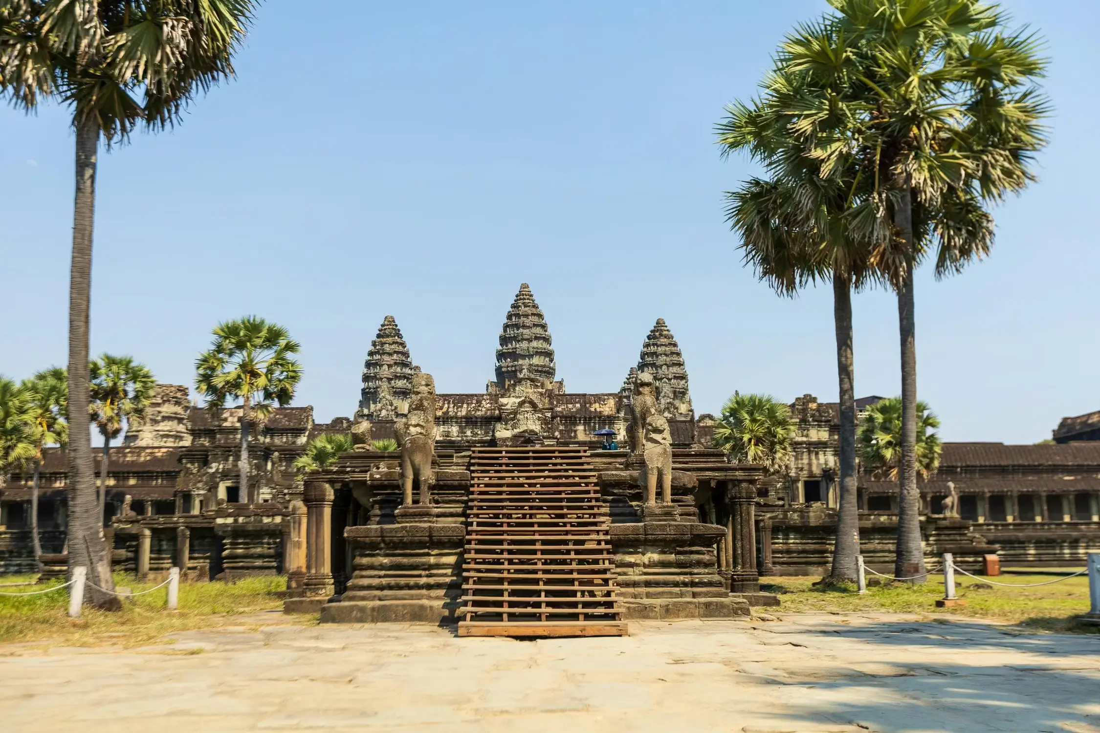 Front entrance of Angkor Wat ancient Khmer temple with stone lion statues and wooden staircase, Cambodia UNESCO World Heritage Site