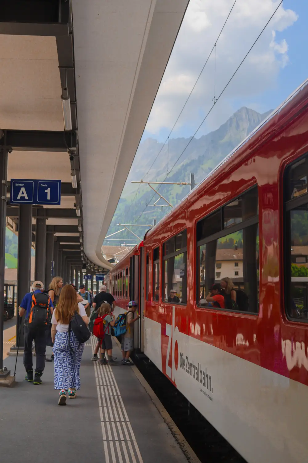 Passengers boarding a red train on a station platform, Switzerland