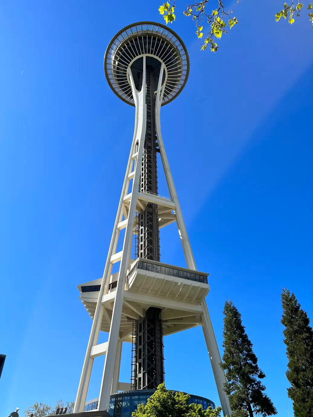 Looking straight up at Seattle's Space Needle against a clear blue sky.