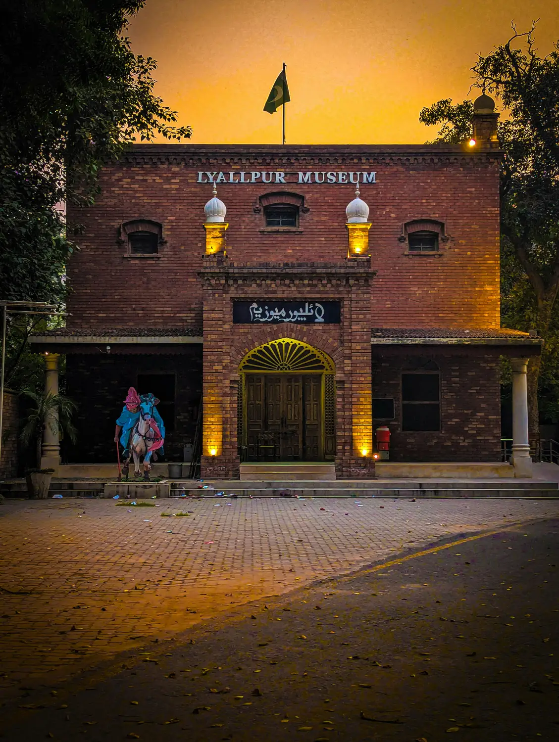 Lahore Museum historic red brick building illuminated at golden hour dusk Pakistan