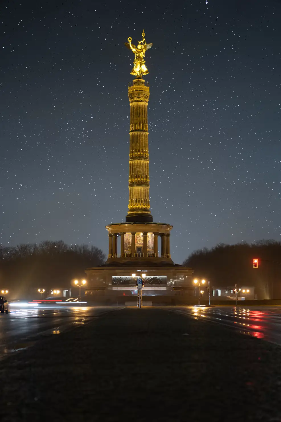 Berlin Victory Column (Siegessäule) illuminated at night with light-trail traffic