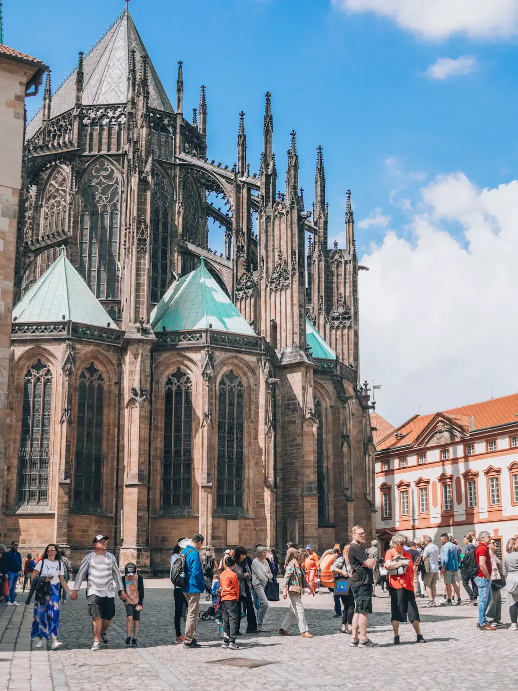 Tourists gathered outside the Gothic facade of St. Vitus Cathedral in Prague