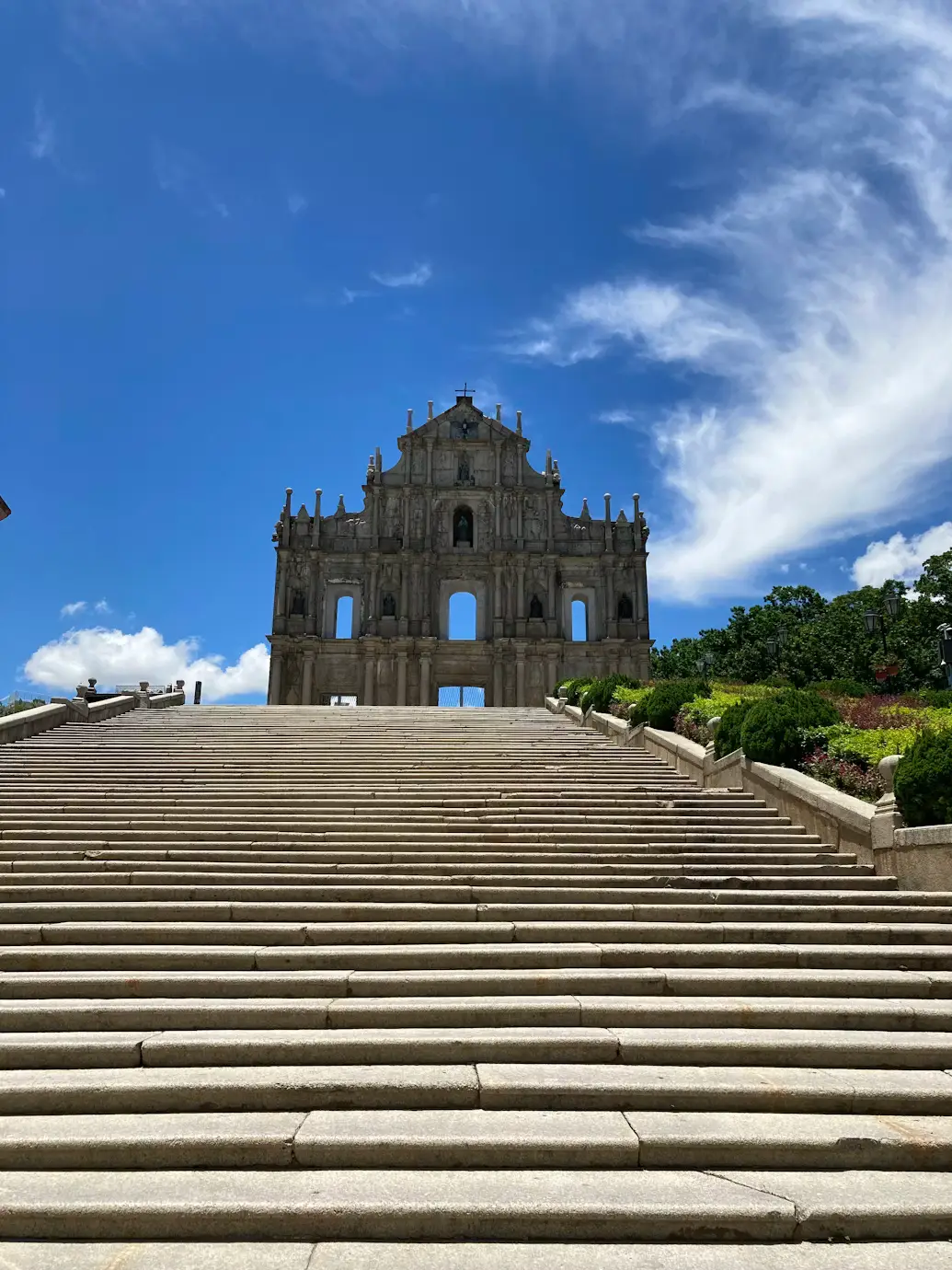 Stone staircase leading up to the Ruins of St. Paul's facade against a blue sky, Macau