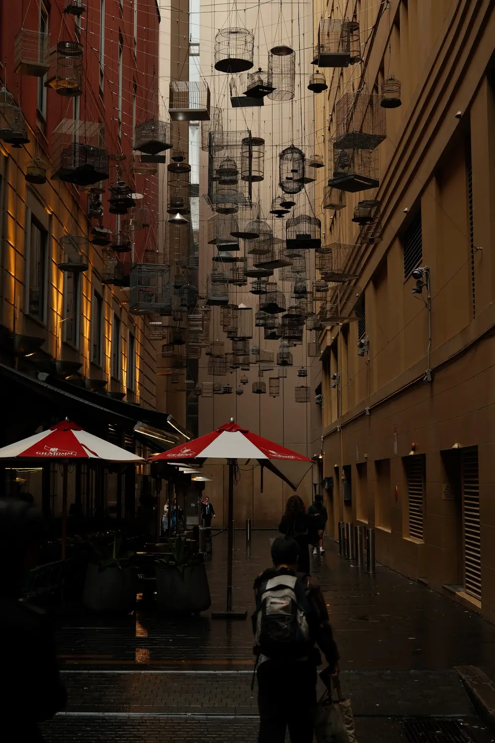 Narrow laneway with hanging lanterns and outdoor cafe umbrellas in The Rocks, Sydney