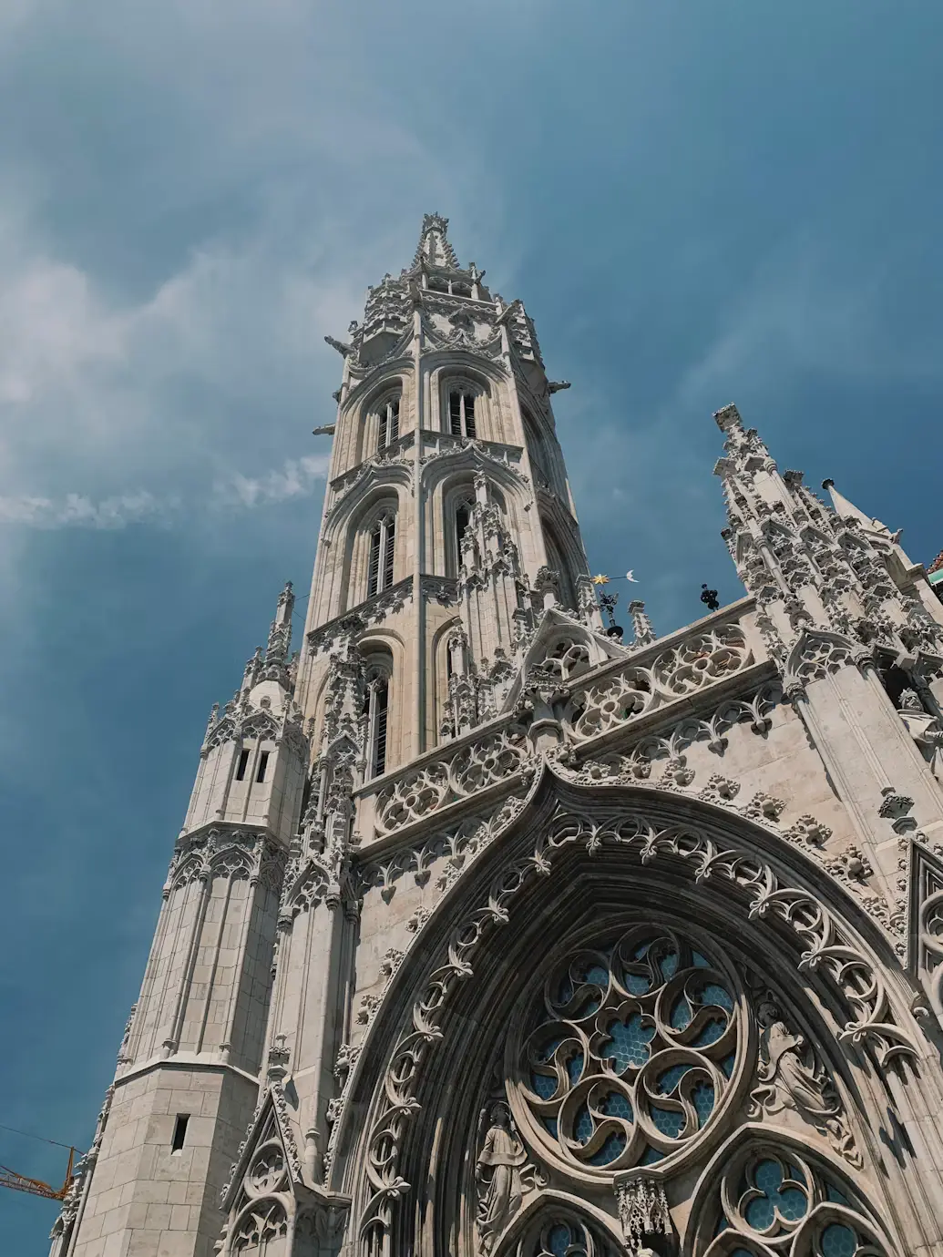 Ornate Gothic church tower and intricate stone facade viewed from below.