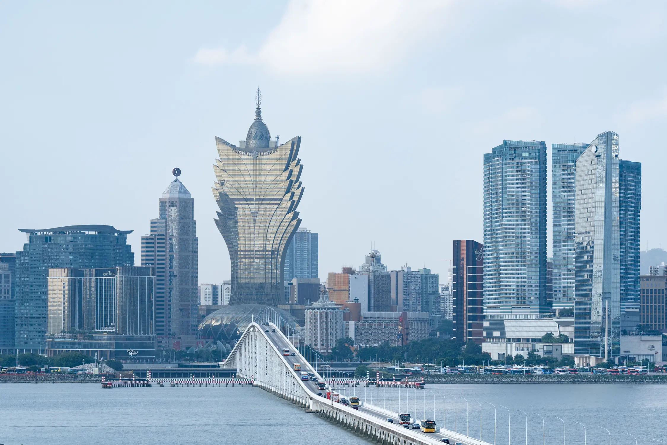 Macau skyline with Grand Lisboa tower and waterfront bridge over harbor