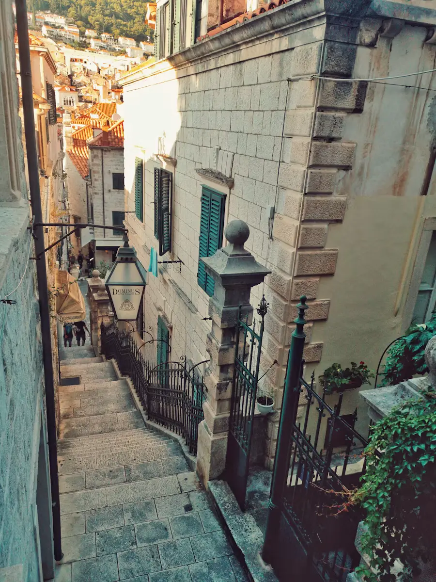 Narrow stone staircase alley between old stone buildings in a historic coastal town.